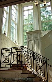 A staircase with iron railing and white walls.