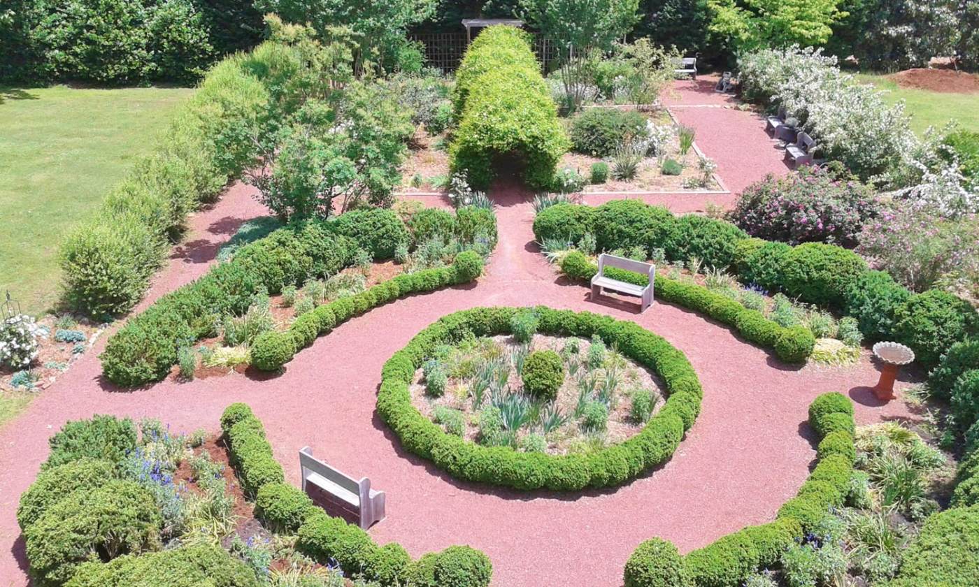 barringtonhallroswell A circular garden with benches and trees
