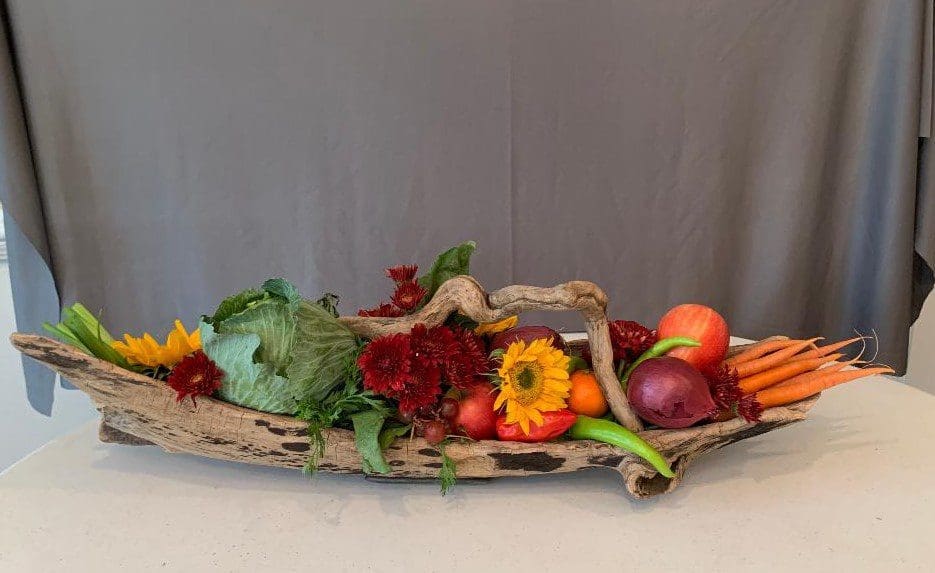 fruits A wooden bowl filled with fruit and vegetables.