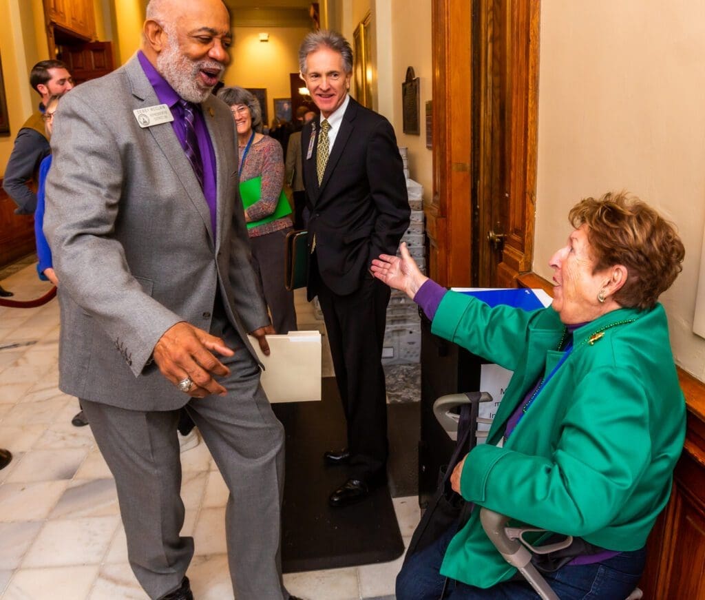 A man in a suit and tie talking to an older woman.