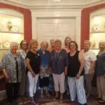 group photo with red shelves in background