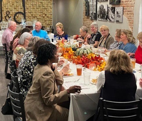 A group of people sitting at a table with food.