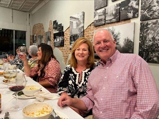 A man and woman sitting at a table with plates of food.