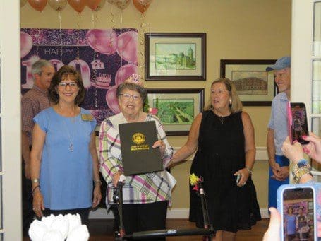 A group of people standing around a room.