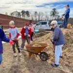 people gardening with a wheelbarrow