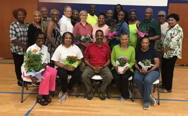 A group of people holding flowers posing for a picture.