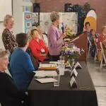 A group of people standing around a table.