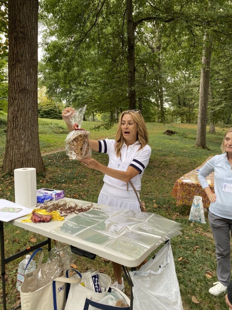 A woman holding an owl at a picnic table.