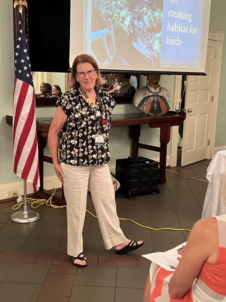 A woman standing in front of an american flag.