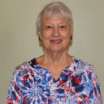 Portrait of a smiling elderly woman with short gray hair.
