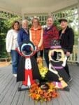 Women posing with Halloween cutouts in gazebo