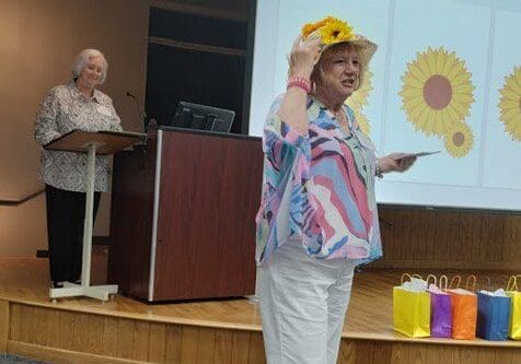 LeadershipAwardsWorkshop A woman wearing a yellow hat and holding up a balloon.