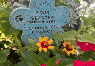 A blue flower with the words " four seasons garden club community project ".